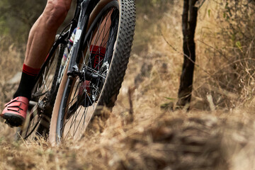 A close-up of a mountain bike in action on rough terrain. The gears and suspension are captured with great clarity, conveying strength, endurance, and adrenaline.