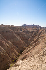 Eroded rock formations under blue sky in Badlands National Park, South Dakota