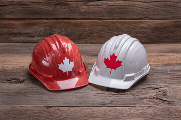 Safety Helmets with Canadian Flag Motif on Rustic Wooden Background