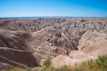 Eroded rock formations under blue sky in Badlands National Park, South Dakota