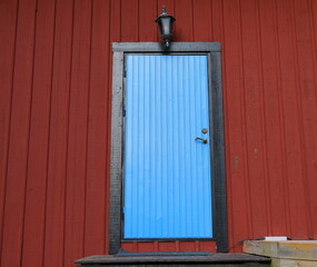 Blue door on red wooden wall.