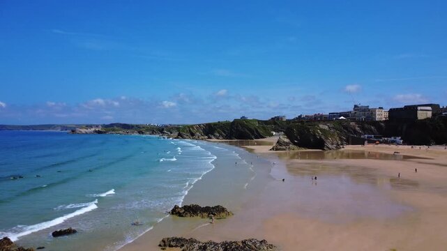 Long coastline with waves, cliffs, and distant beach town