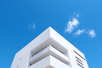 Angular architecture contrasts vividly against the crisp blue sky, a modern structure with a touch of minimalist design.