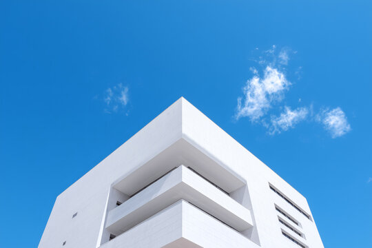 Angular architecture contrasts vividly against the crisp blue sky, a modern structure with a touch of minimalist design.