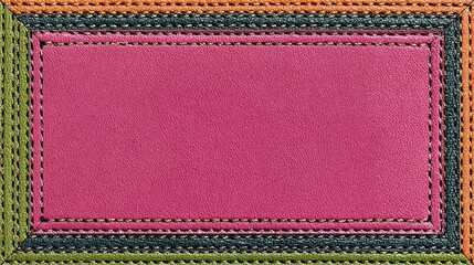 A rectangular pink leather patch is framed by a layered border of stitched greens, teal, orange, and yellow