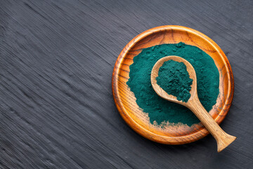 Organic spirulina powder in a spoon and bowl - Healthy food