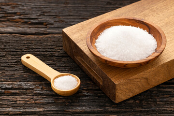 Fine grains of refined white sugar in a bowl and spoon - Saccharum officinarum