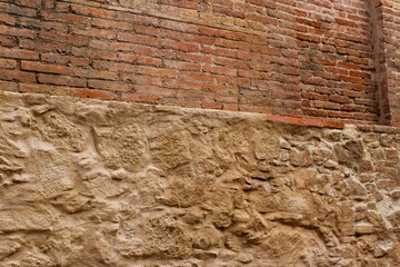 Red brick wall built on a stone wall