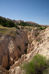 Eroded rock formations and green trees in Badlands National Park, South Dakota