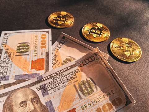 Golden Bitcoin coins placed on prop US dollar bills