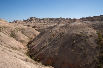Open grassland with distant Badlands rock formations.