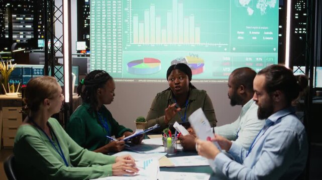 Multiethnic group of advisors reviewing data insights and financial situation on papers, preparing updates for the shareholders and establishing the project agenda and objectives. Camera A.