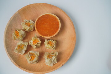 siomay dim sum with sauce on wooden plate