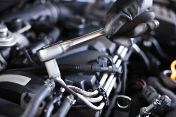 Auto parts. Professional mechanic with torque wrench fixing car indoors, closeup