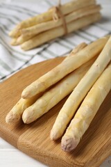 Raw asparagus spears on white wooden table, closeup