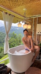 Handsome Man Soaking in Bubble Bath with Breathtaking Mountain Sunset View