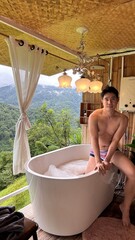 Handsome Man Relaxing in Bubble Bath on Veranda Amidst Lush Green Forest and Gentle Rain
