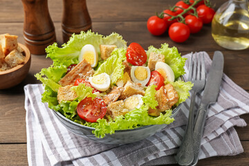 Delicious salad with croutons and ingredients on wooden table, closeup
