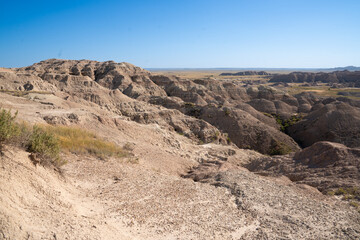 Open grassland with distant Badlands rock formations.
