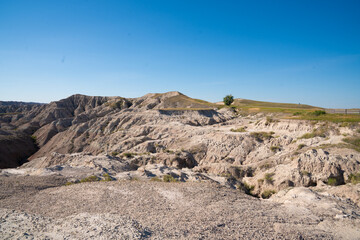 Open grassland with distant Badlands rock formations.