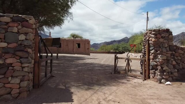 Aerial drone view, simulating a quick entry through the gate to appreciate the buildings of the Mayorazgo de Anillaco, a key point on the historical Adobe Route of Catamarca, Argentina.