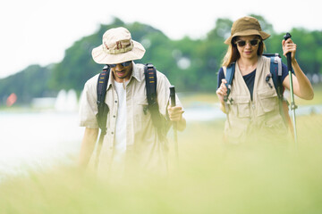 Man and woman are enjoy seeing a beautiful landscape and lake view while hiking.