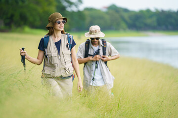 Man and woman are enjoy seeing a beautiful landscape and lake view while hiking.
