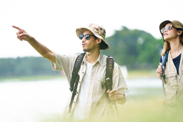 Man and woman are enjoy seeing a beautiful landscape and lake view while hiking.