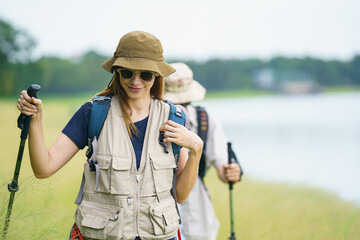Man and woman are enjoy seeing a beautiful landscape and lake view while hiking.