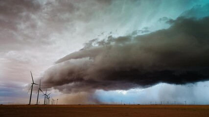 Dark storm clouds roll in across renewable energy wind farms  - Powered by Adobe