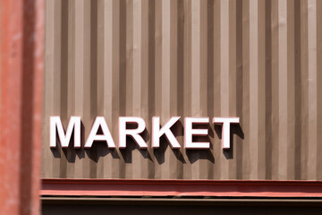 Bold word “Market” mounted on a corrugated aluzinc metal wall. Ideal for industrial, signage,...
