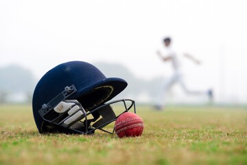 Cricket Helmet and Ball on Grass – Action Scene with Running Player
