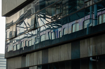 Modern urban scene with train reflected in skyscraper windows