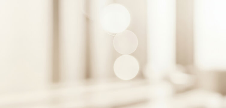 Abstract blurred background with beige tones and bokeh lights creating a soft effect, evoking a delicate ambient glow that enhances the warmth and visual calmness of the scene.