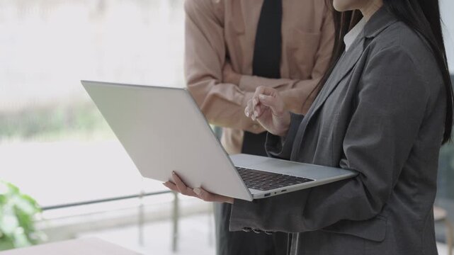 Asian businesswoman explaining document on blank white tablet in conference room using computer, talking, discussing and solving business problems faced.