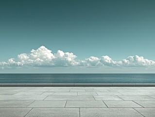 Tranquil coastal vista. Empty paved promenade stretches to horizon. Vast ocean meets a pale blue sky with puffy clouds