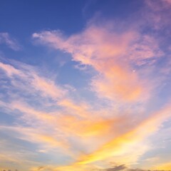 Obraz premium Colorful wispy clouds fill a serene blue sky at dusk or dawn light