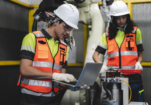 Smart Latino engineer working on AI technology in robotics electronics engineering laboratory. Hispanic students' research project is programming robot machine with intelligent mechanical control - Powered by Adobe