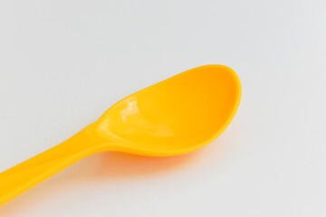 yellow spoon isolated on white background, plastic cutlery for picnic