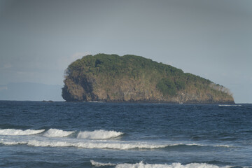 Lone Green Island Amid Blue Waves