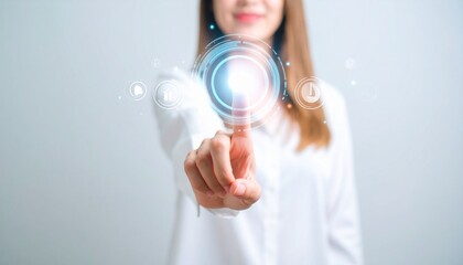 Young woman touching futuristic digital interface with finger, demonstrating the concept of innovation, technology and connectivity.  Clean grey background highlights the,woman touching virtual screen