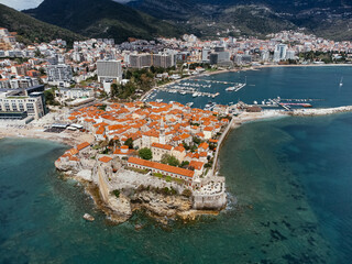 Aerial view of Old Town Budva on the Adriatic coast, Montenegro, with marina and red-tiled roofs. g.