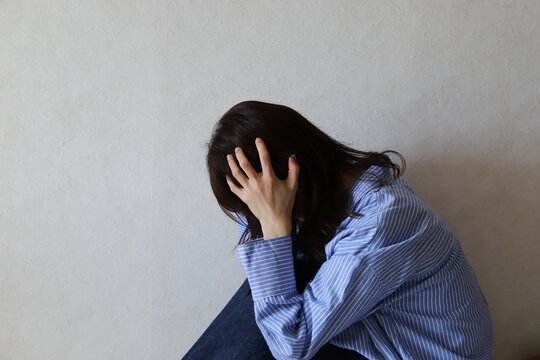 下を向いて落ち込む女性