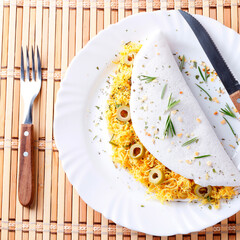 homemade tapioca or beiju stuffed with boiled chicken and olives on rustic wooden table