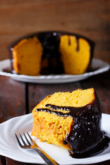 Slice of carrot cake with chocolate frosting on a ceramic plate. homemade Brazilian dessert