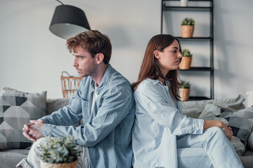 Beautiful lady is depressed, sitting on the couch talking to man, having a dispute with husband or...
