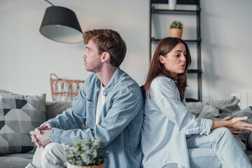 Beautiful lady is depressed, sitting on the couch talking to man, having a dispute with husband or...