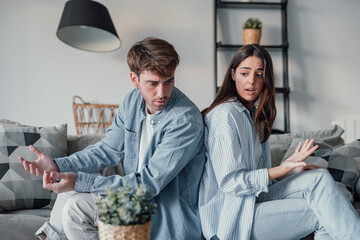 Beautiful lady is depressed, sitting on the couch talking to man, having a dispute with husband or...