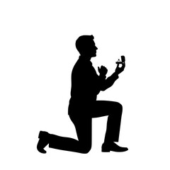 Silhouette of a man proposing while kneeling and holding an open ring box with a ring inside his hand