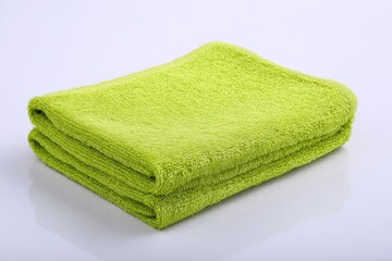 Folded lime green towel on white background (1)